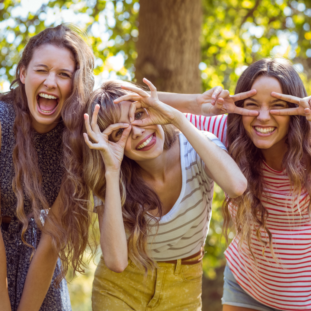 Freundinnen lachen und schneiden herzliche Grimassen während den Vorbereitungen für unser Teambuidling Outdoor Event im Sommer