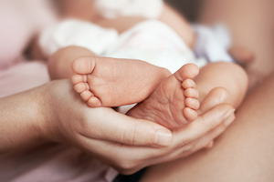 Babysitterin mit viel Erfahrung in der Saeglingspflege haelt ein Neugeborenes
