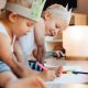 Zwei Kinder sitzen am Boden und malen mit Buntstiften während eines Babysitter Kurses